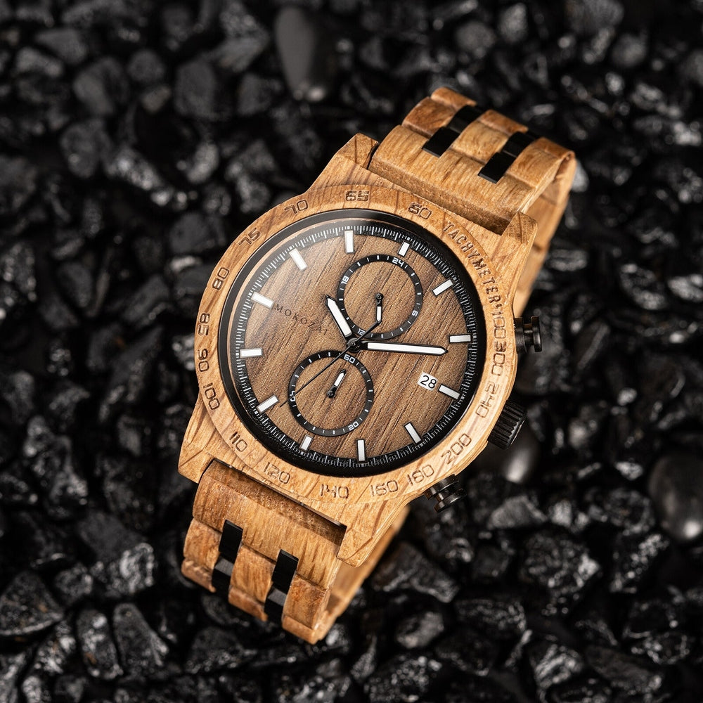Mokozai wooden wristwatch featuring a detailed natural wood grain dial, black subdials, and white accents, displayed on a black textured surface for a bold contrast.
