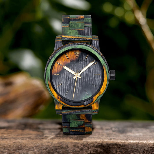 Mokozai wristwatch with vibrant green, yellow, and black wooden bezel and strap, featuring a sleek black face with minimalist gold hands, set against a natural outdoor backdrop.